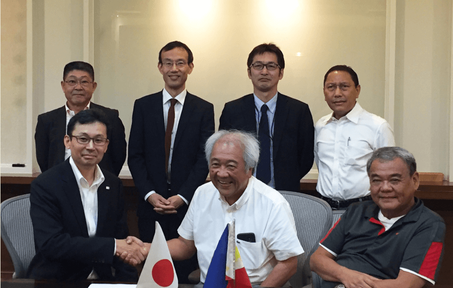 Takao Konishi, Vice President of Toshiba’s Thermal & Hydro Power Systems & Services Div. (left), shakes hands on the agreement with Victor A. Consunji, President and COO of SCPC (center), as Isidro A. Consunji, President and CEO of DMCI Holdings (right) and Jaime B. Garcia, Vice President of Procurement & Logistics, Semirara Mining & Power Corporation (back row, right) look on.