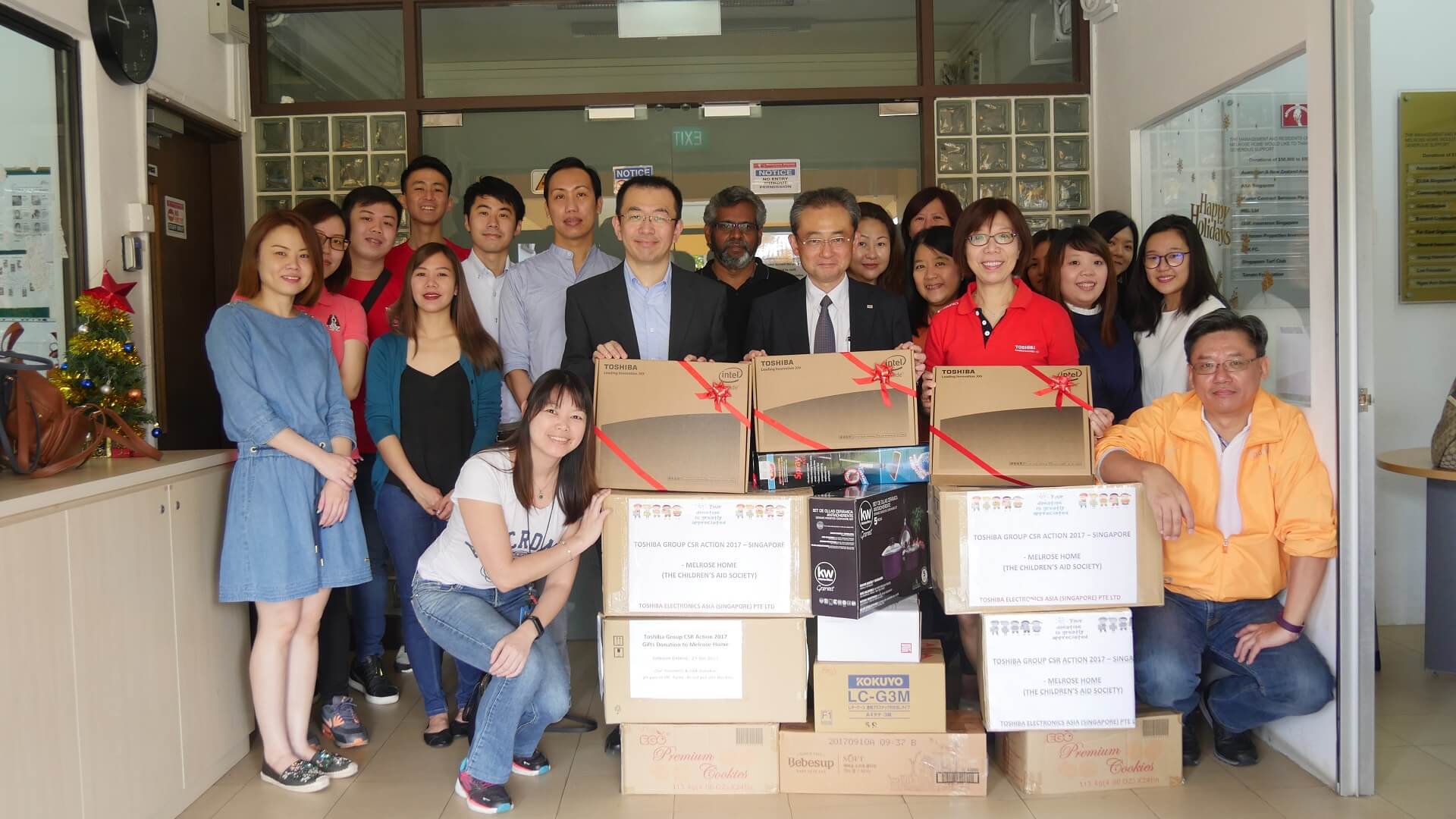 Employees from Toshiba group companies in Singapore with donations and gifts for Melrose Home