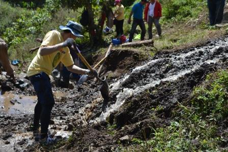 TIP staff cultivating soil in a farming field